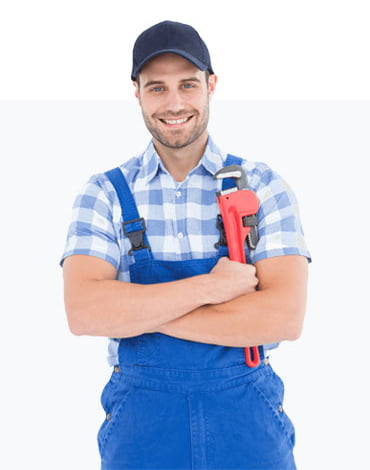 Man in a blue cap, blue overalls, and a checkered shirt, holding a red pipe wrench while smiling at the camera—a proud member of the construction team.